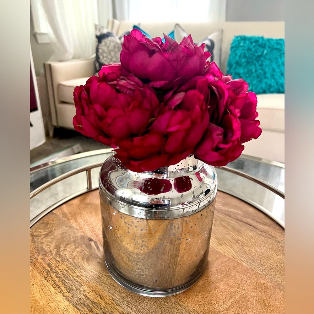 Glam mirror vase with fuchsia flowers.